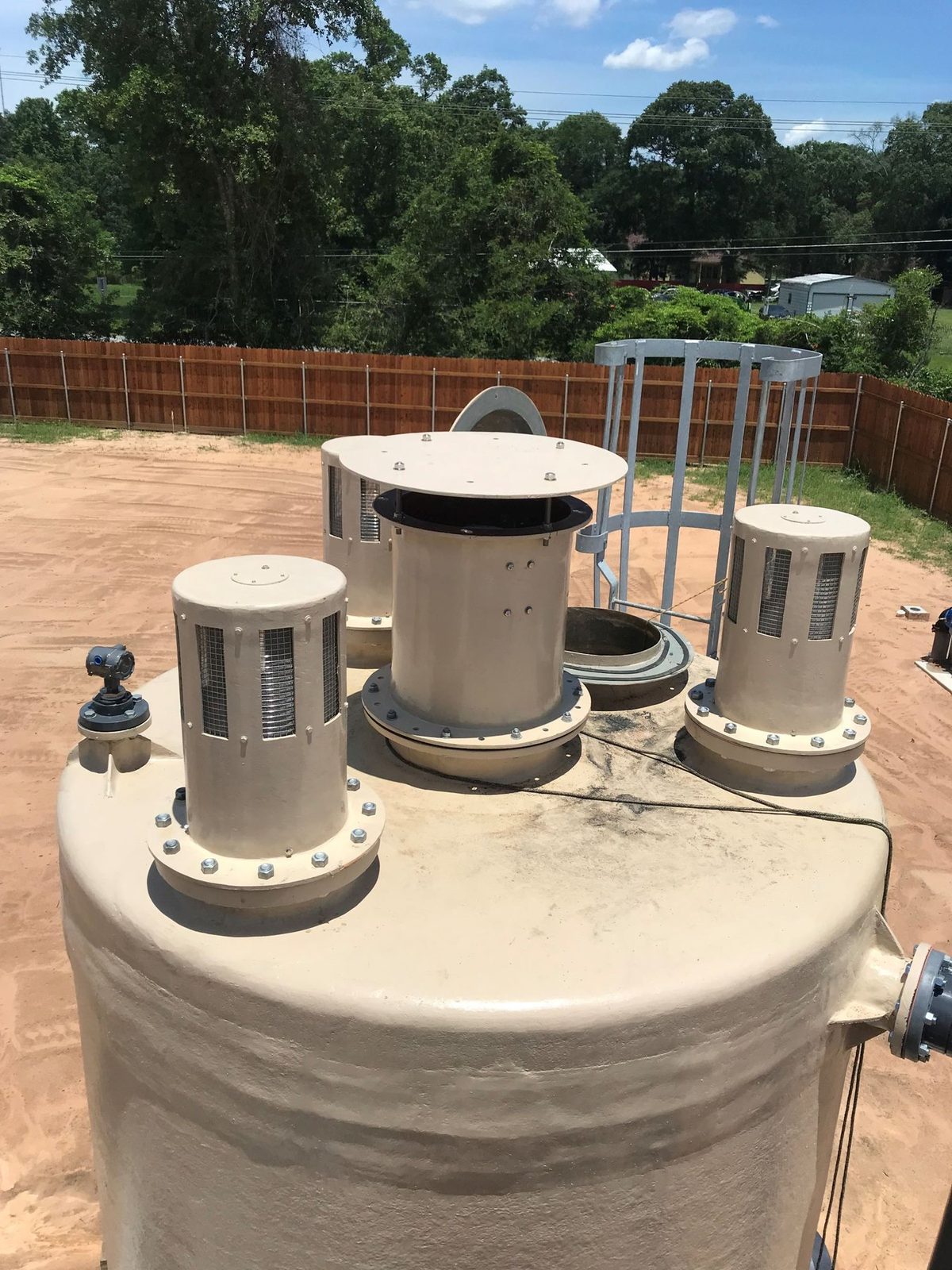 Three ventilation stacks with mist eliminator screens on a tank roof
